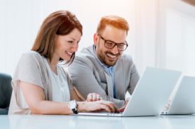 Mann und Frau sitzen am Laptop